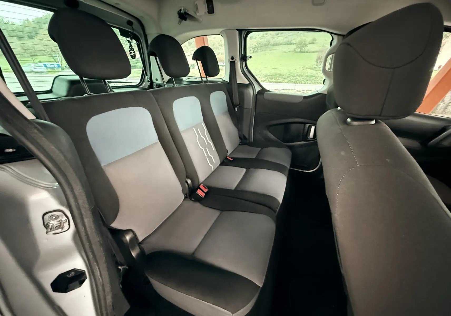 Vue intérieure côté droit montrant la banquette arrière grise et noire du Peugeot Partner Tepee 2014 avec trois appuie-têtes.
