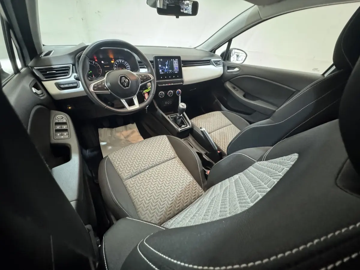 Vue intérieure avant droite de la Renault Clio Business TCe 100 GPL 2023, sièges tissu gris et tableau de bord avec écran tactile.