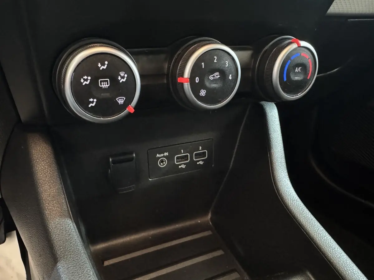Détail des commandes de climatisation et ports USB dans l’habitacle noir de la Renault Clio Business TCe 100 GPL 2023.