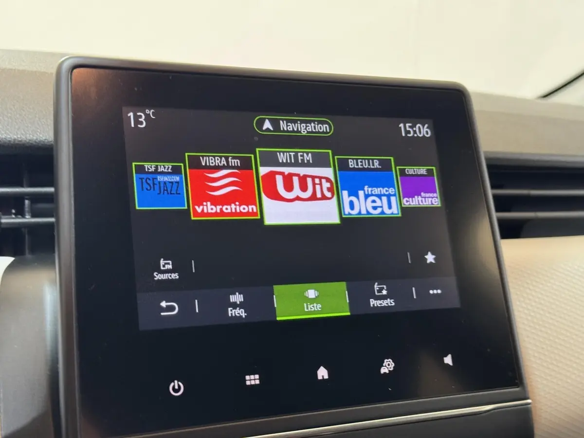 Écran tactile central de la Renault Clio Business blanc, affichant les stations radio et la navigation à 15h06.