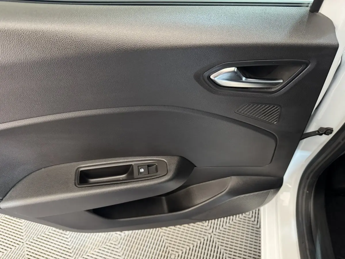 Vue intérieure côté gauche de la porte avant blanche d'une Renault Clio Business TCe 100 GPL avec poignée et commande de verrouillage.