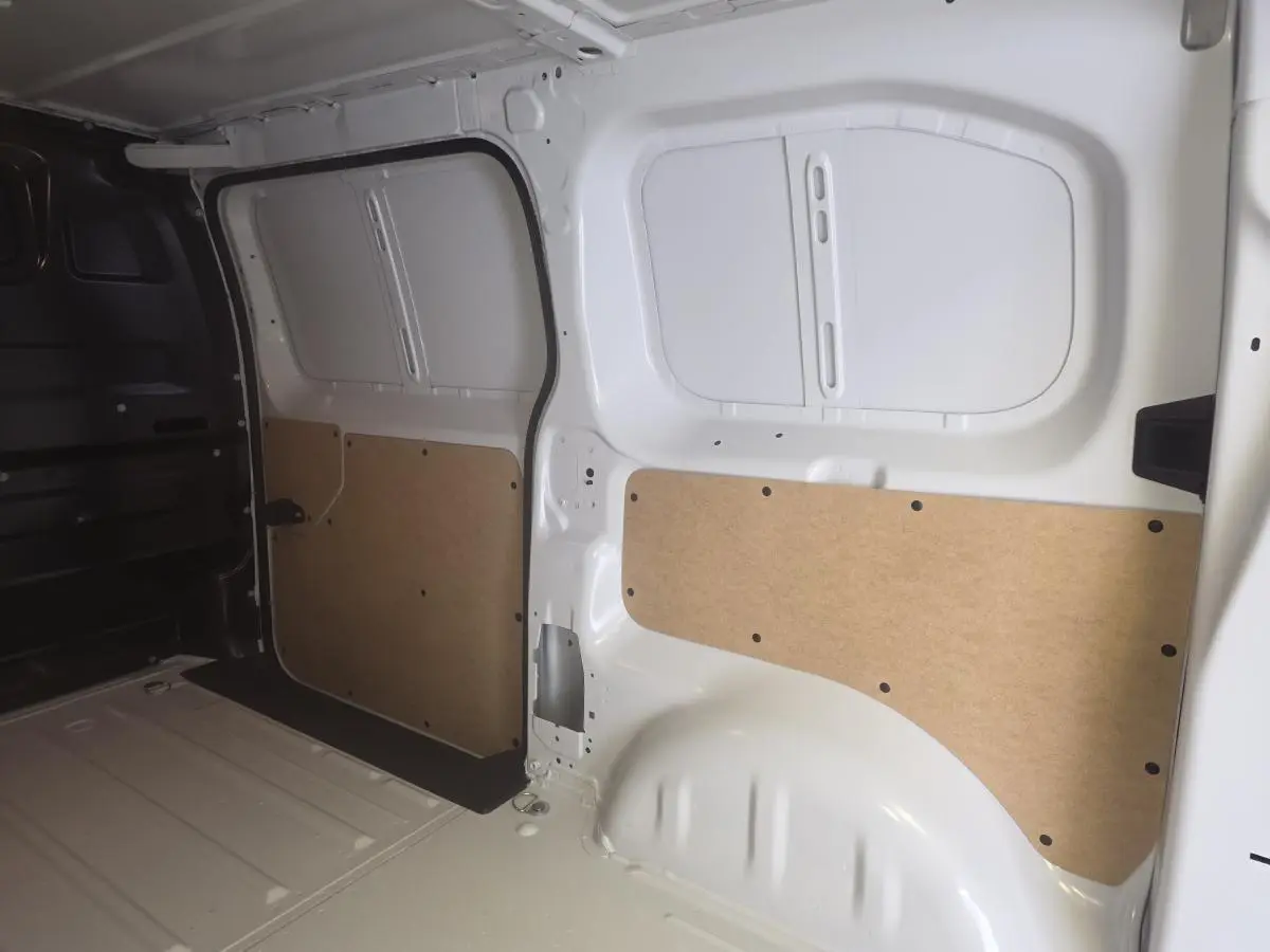 Intérieur du coffre blanc de l'Opel Vivaro 2025, vue latérale droite avec panneaux de protection en bois clair.