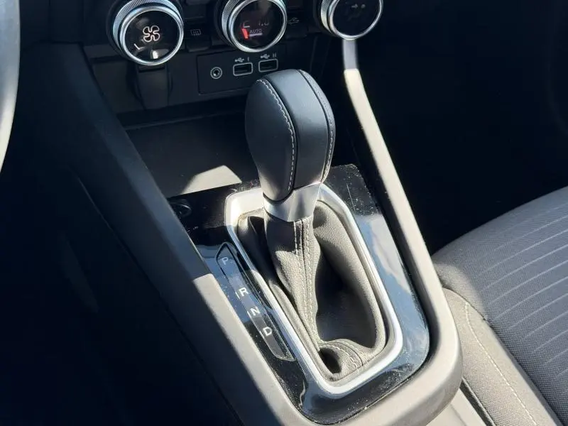 Gros plan sur la commande de boîte automatique noire du Renault Arkana 2025, avec console et commandes de climatisation visibles.