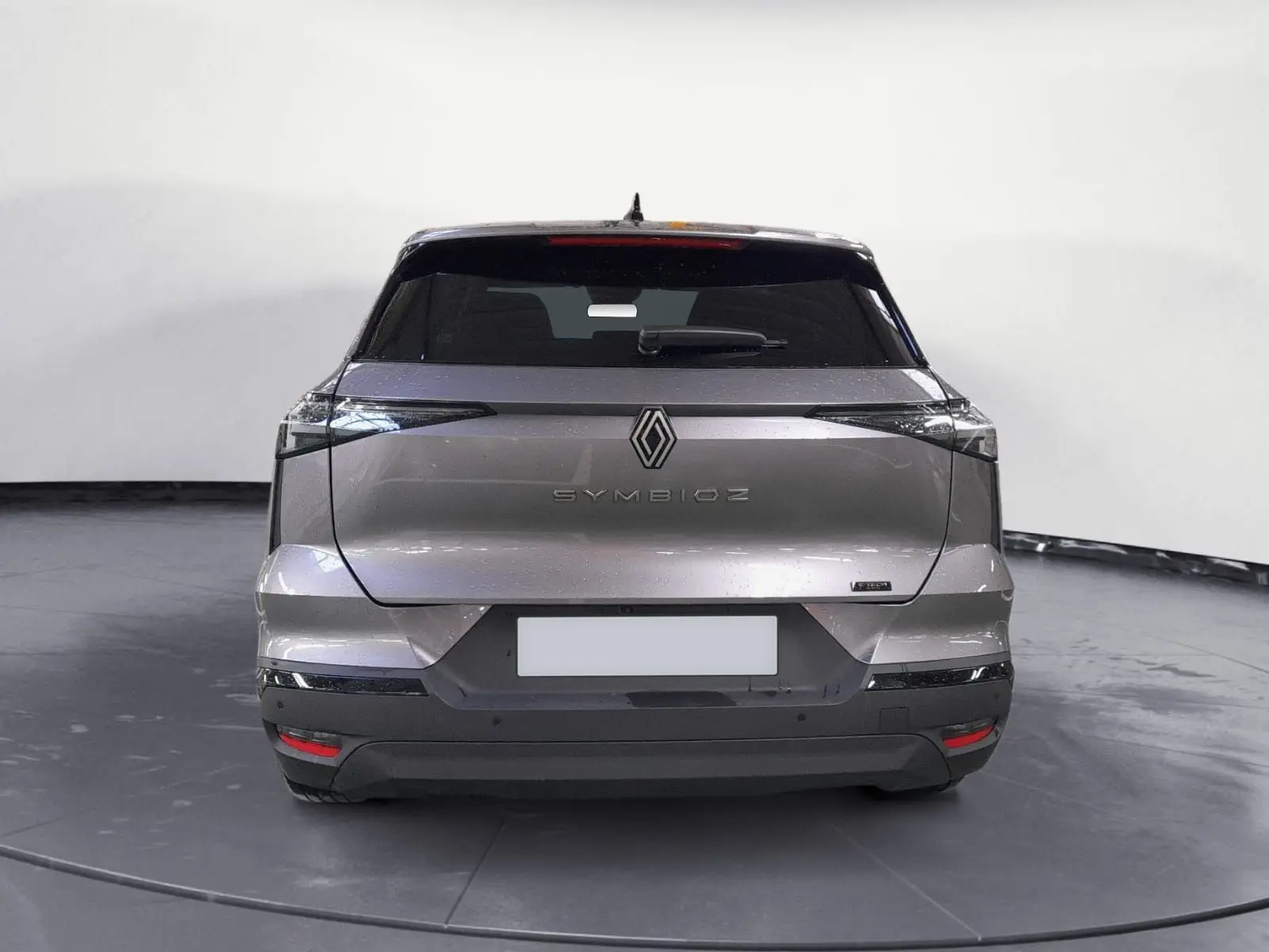 Vue arrière d’un Renault SYMBIOZ gris cassiopée 2025 avec feux étirés et logo central lumineux.