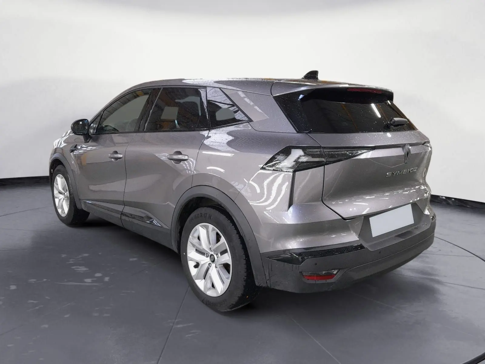Vue 3/4 arrière droite du Renault Symbioz gris Cassiopée, soulignant ses lignes modernes et ses feux arrière distinctifs.