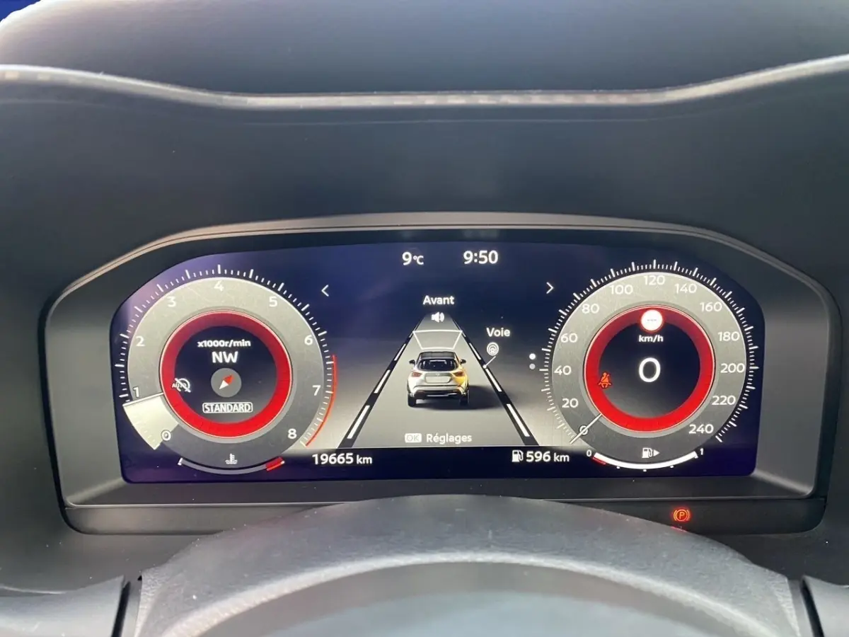 Vue rapprochée du tableau de bord numérique du Nissan Juke 2025, affichage rouge et noir avec compteur et vitesse à zéro.