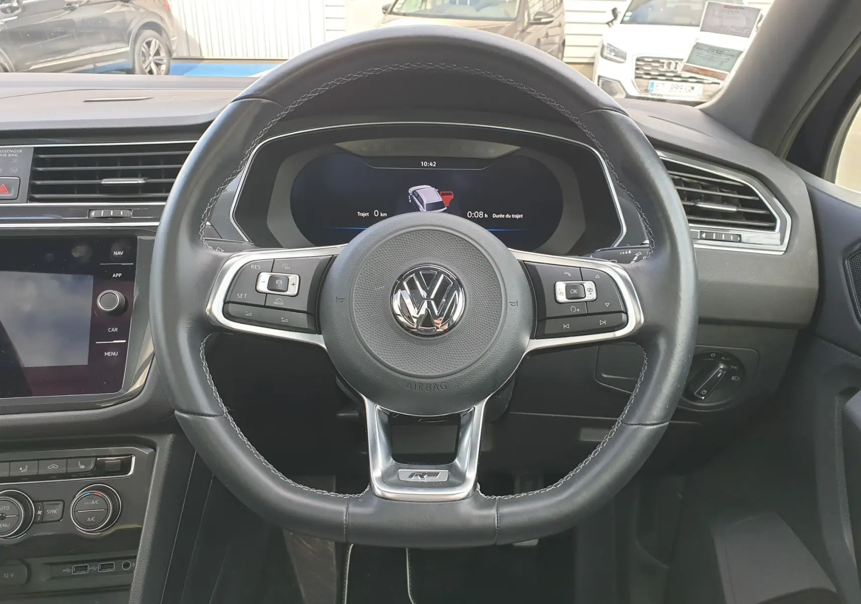 Vue centrée sur le volant cuir noir du Volkswagen Tiguan 2018 avec tableau de bord digital et conduite à droite.