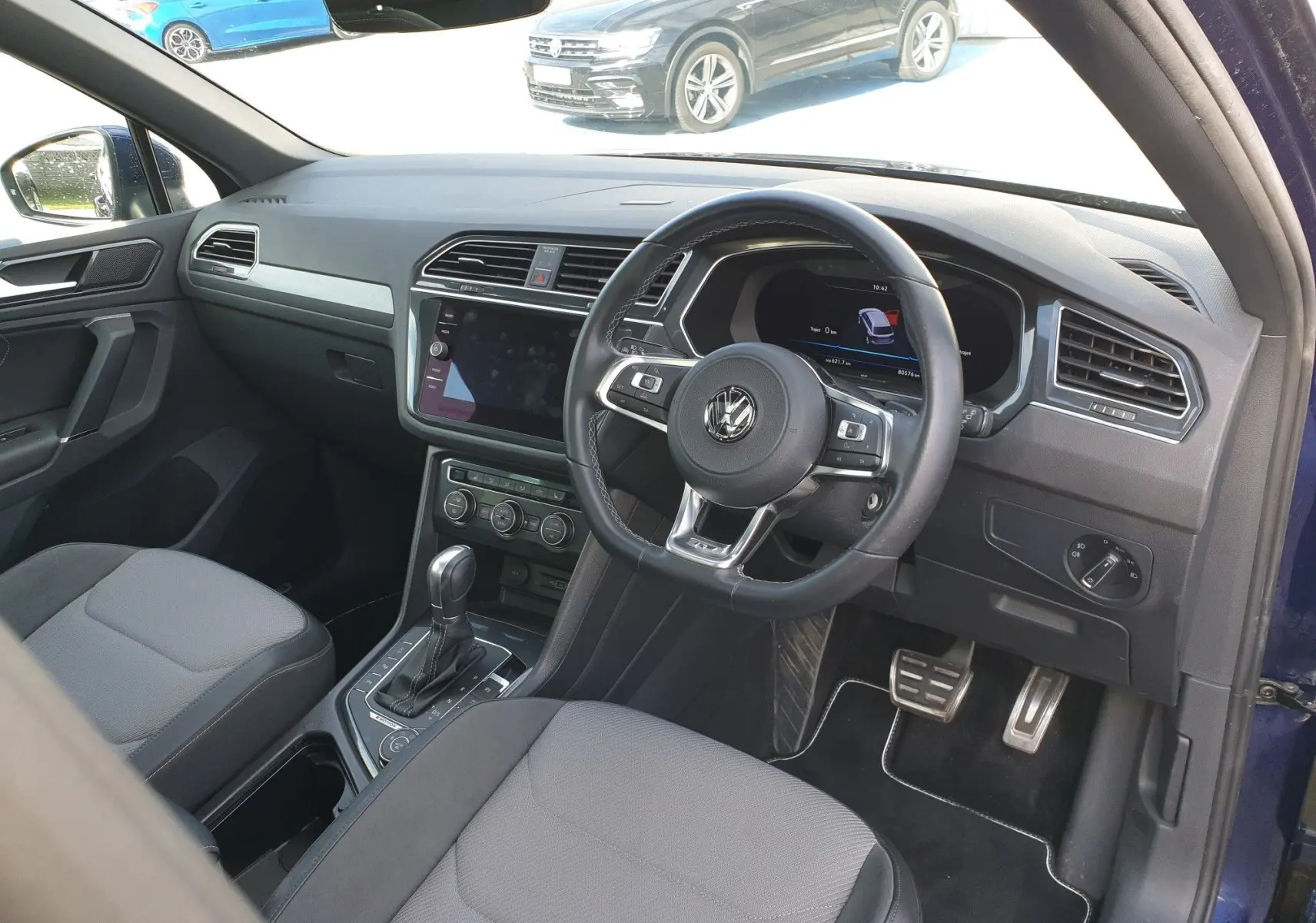 Intérieur du Volkswagen Tiguan 2018 essence bleu, vue côté conducteur à droite avec tableau de bord et volant multifonction.