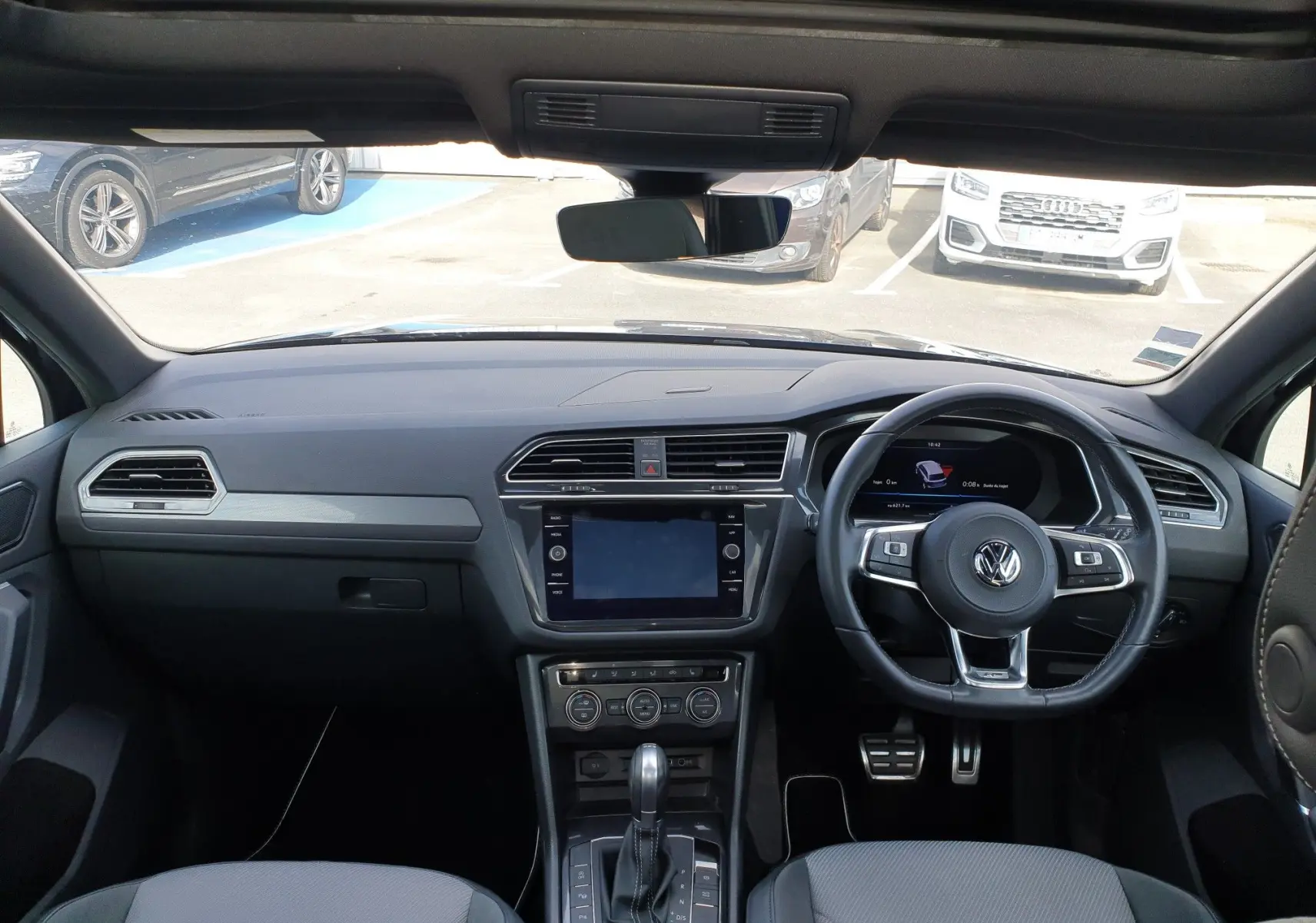 Vue intérieure du tableau de bord et volant à droite d'un Volkswagen Tiguan 2018, finition Carat, avec console centrale moderne.