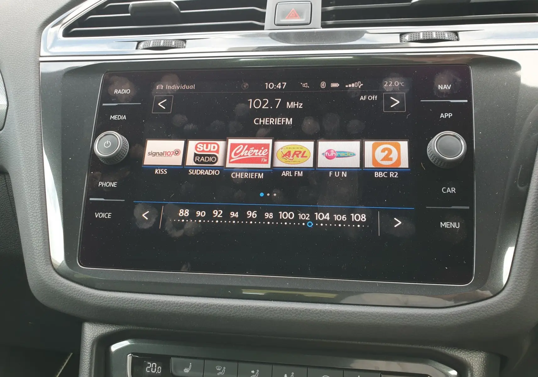 Écran tactile central du Volkswagen Tiguan 2018 montrant la radio FM à 102,7 MHz avec commandes autour en finition noire.