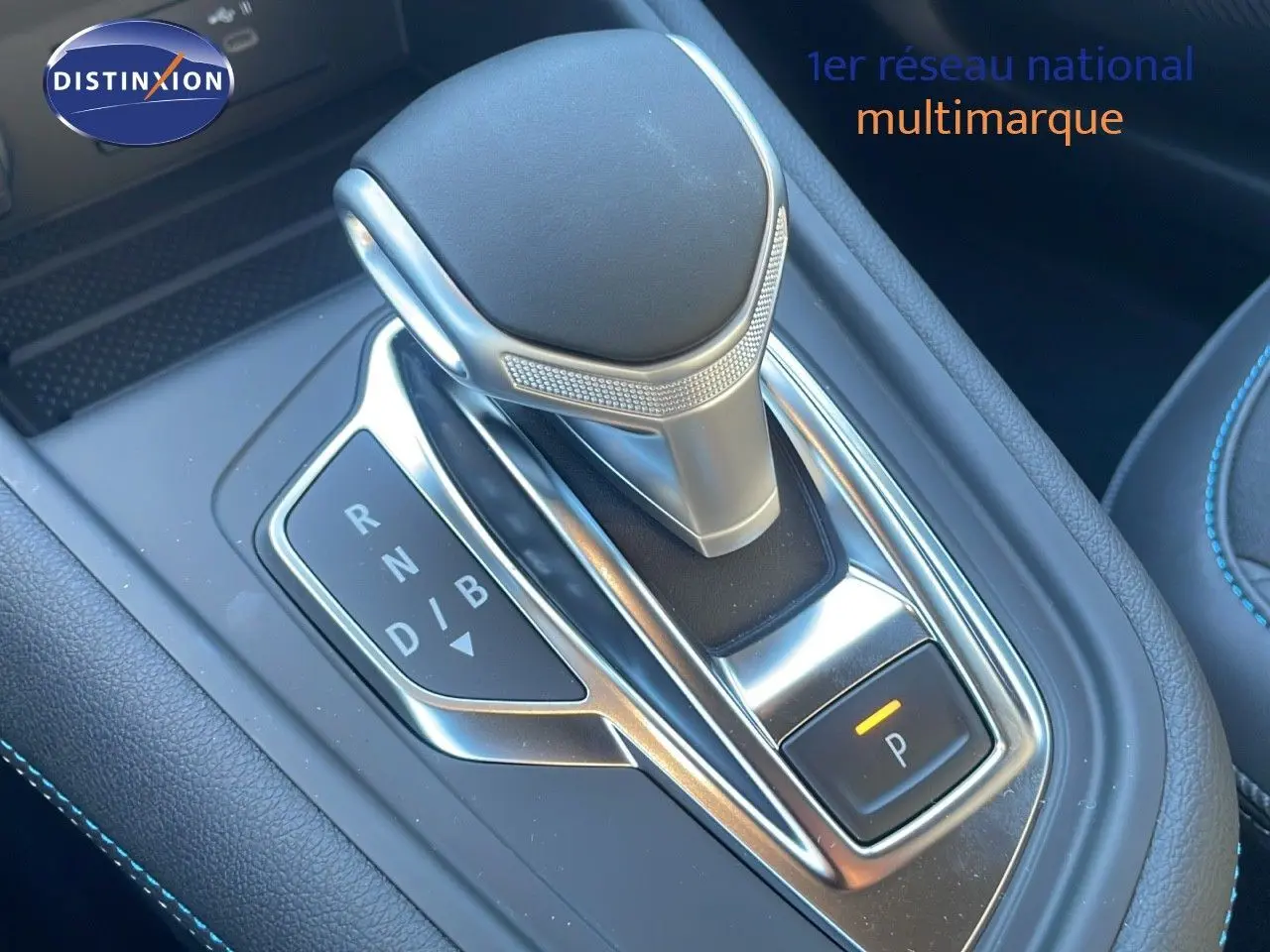 Le levier de vitesses automatique du Renault Captur E-Tech hybride 2025 en gros plan avec surpiqûres bleues.
