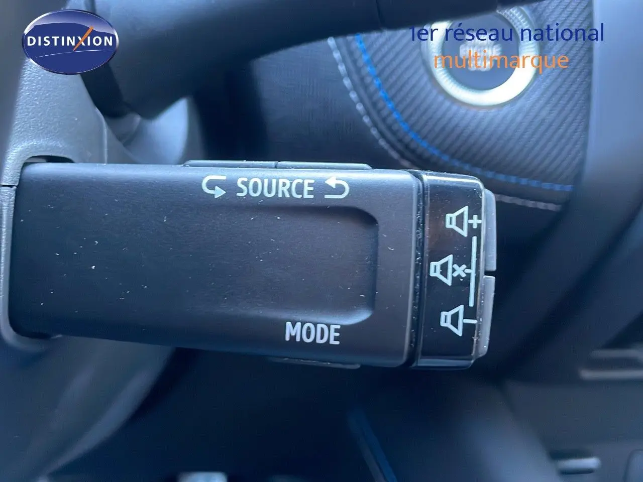 Gros plan sur la commande au volant du Renault Captur noir étoile métal, avec boutons source et mode visibles.