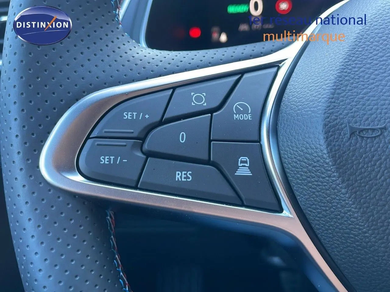 Gros plan sur les commandes du volant en cuir noir perforé du Renault Captur E-Tech hybride 2025, version Esprit Alpine.