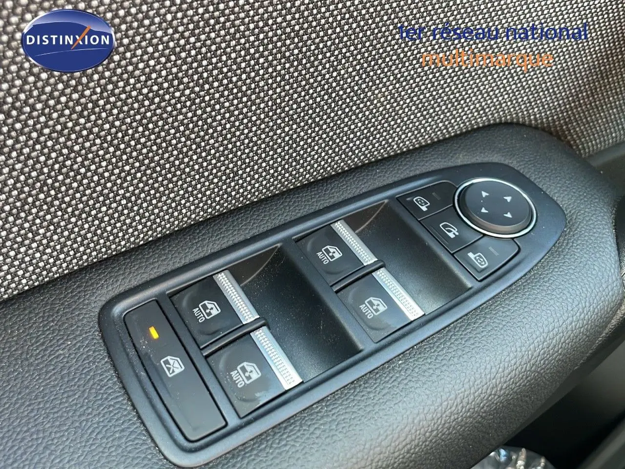 Gros plan sur les commandes des vitres électriques et rétroviseurs du côté conducteur d'un Renault Captur noir étoile métal.