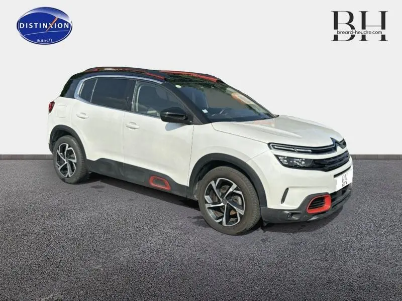Citroën C5 Aircross blanc nacré en 3/4 avant droit avec détails rouges et toit noir contrasté.