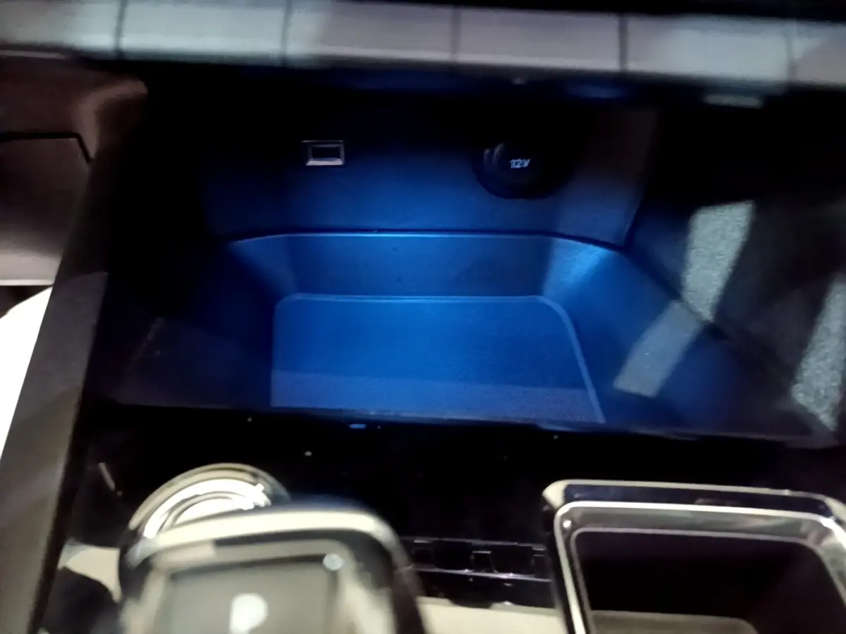 Gros plan sur la console centrale du Peugeot 3008 GT bleu, montrant prise USB et prise 12V avec éclairage bleu.