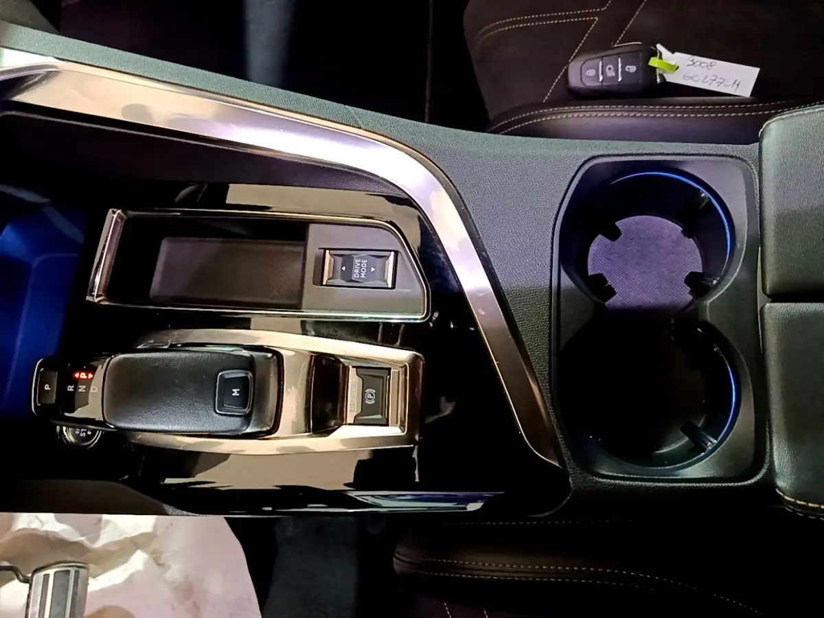 Vue plongeante sur la console centrale noire du Peugeot 3008 GT 2021 avec levier de vitesse et porte-gobelets.