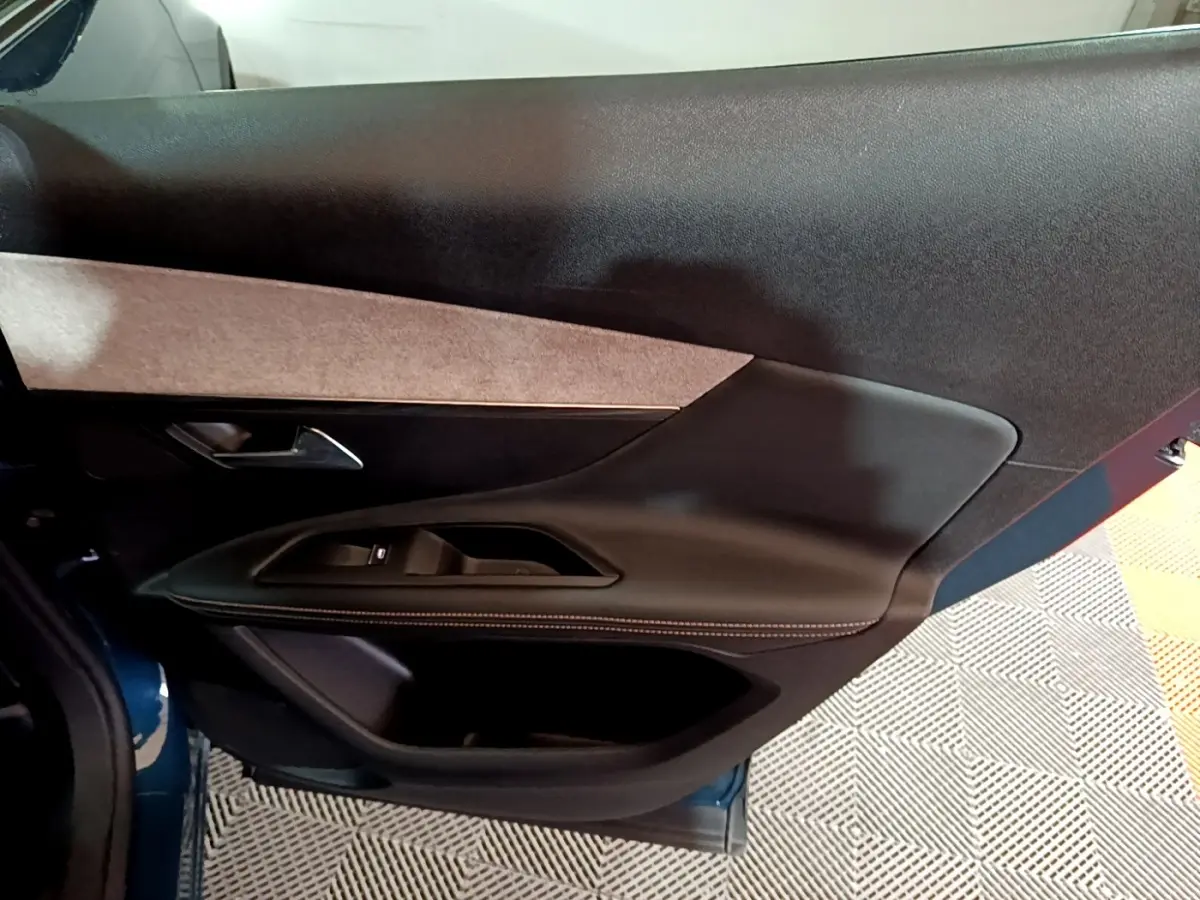 Détail de la porte avant gauche noire avec insert tissu beige du Peugeot 3008 bleu, version GT 2021.