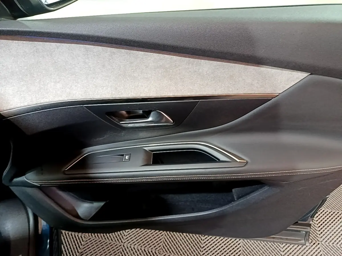 Vue rapprochée de la porte avant gauche du Peugeot 3008 bleu, avec garniture noire et insert gris clair.