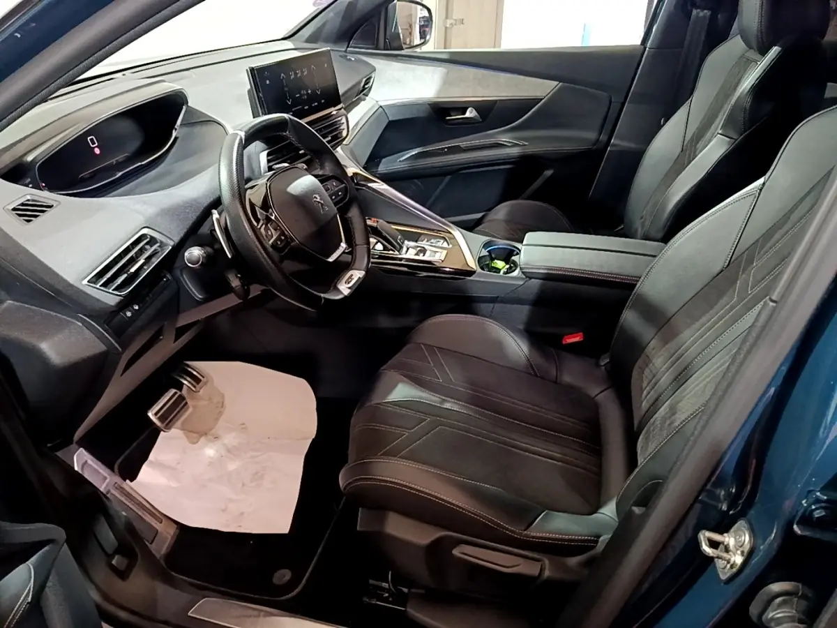 Vue intérieure côté conducteur du Peugeot 3008 bleu 2021, volant cuir multifonctions et écran tactile central visible.