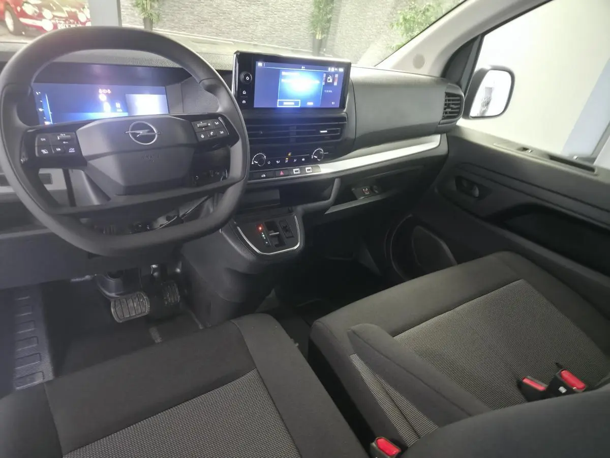 Vue intérieure côté conducteur de l'Opel Vivaro 2025 avec tableau de bord noir, écran tactile 10'' et volant multifonction.
