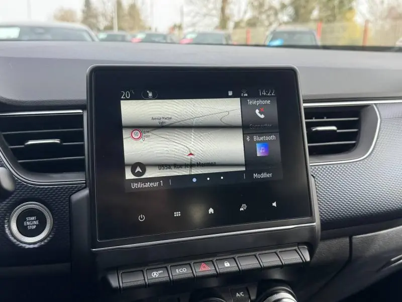 Vue intérieure du tableau de bord du Renault Arkana 2025, écran tactile central avec navigation et commandes autour.