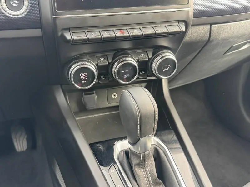 Gros plan sur la console centrale du Renault Arkana blanc 2025, avec levier de boîte auto et commandes climatisation.