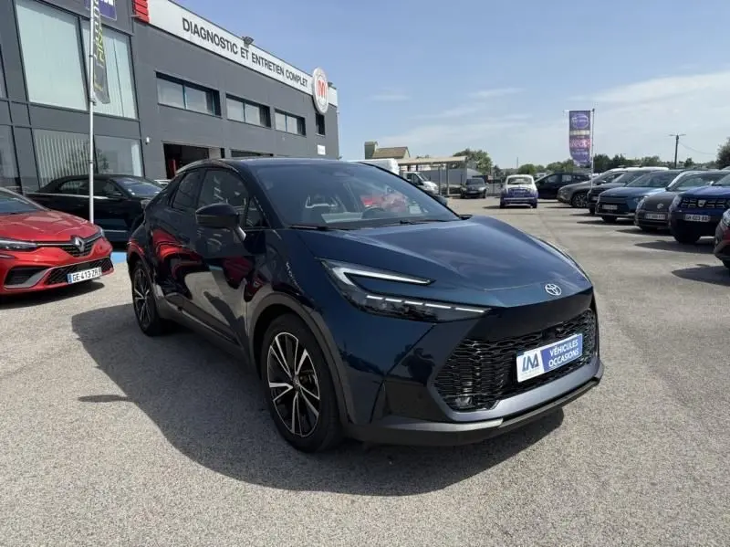 Vue 3/4 avant d'un Toyota C-HR Hybride 2024 bleu persan avec calandre noire et jantes alliage distinctives.