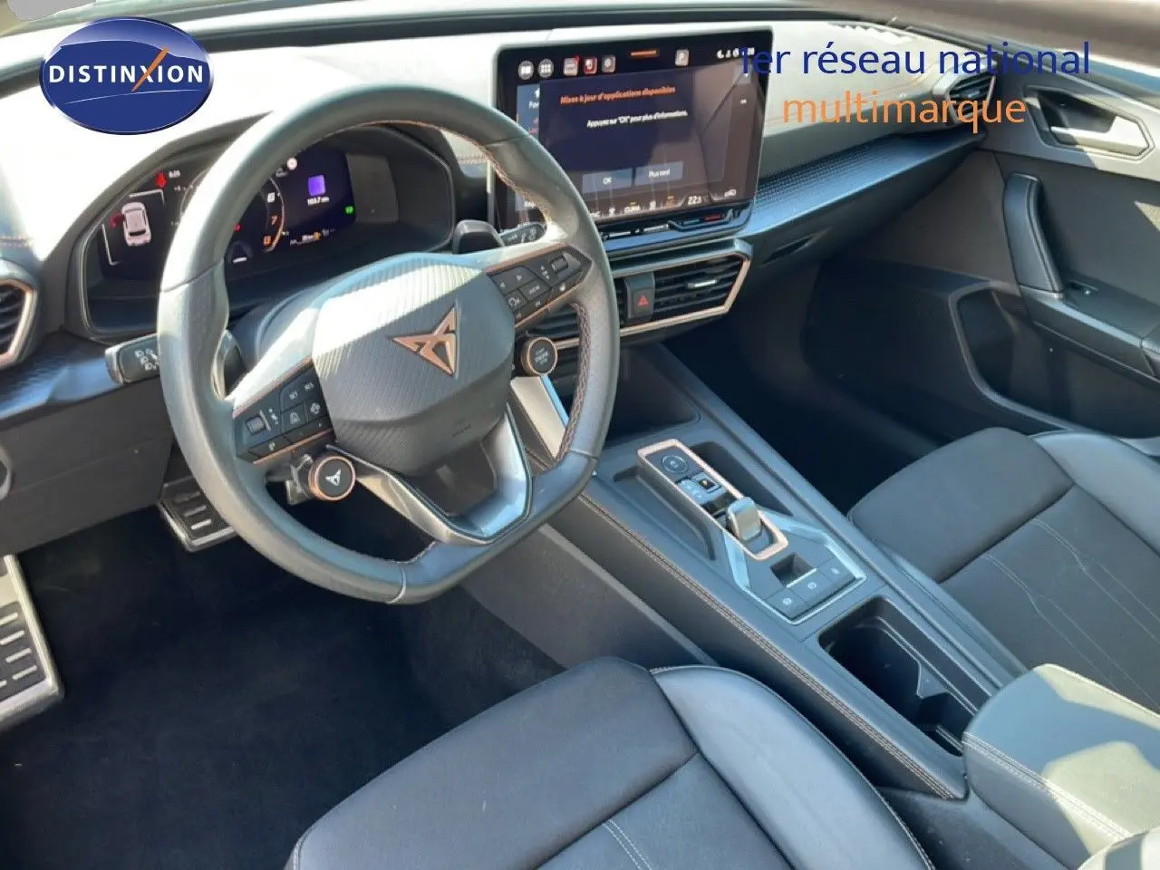 Vue intérieure de face côté conducteur du tableau de bord et volant cuir noir de la CUPRA Leon 1.5 eTSI 2025.