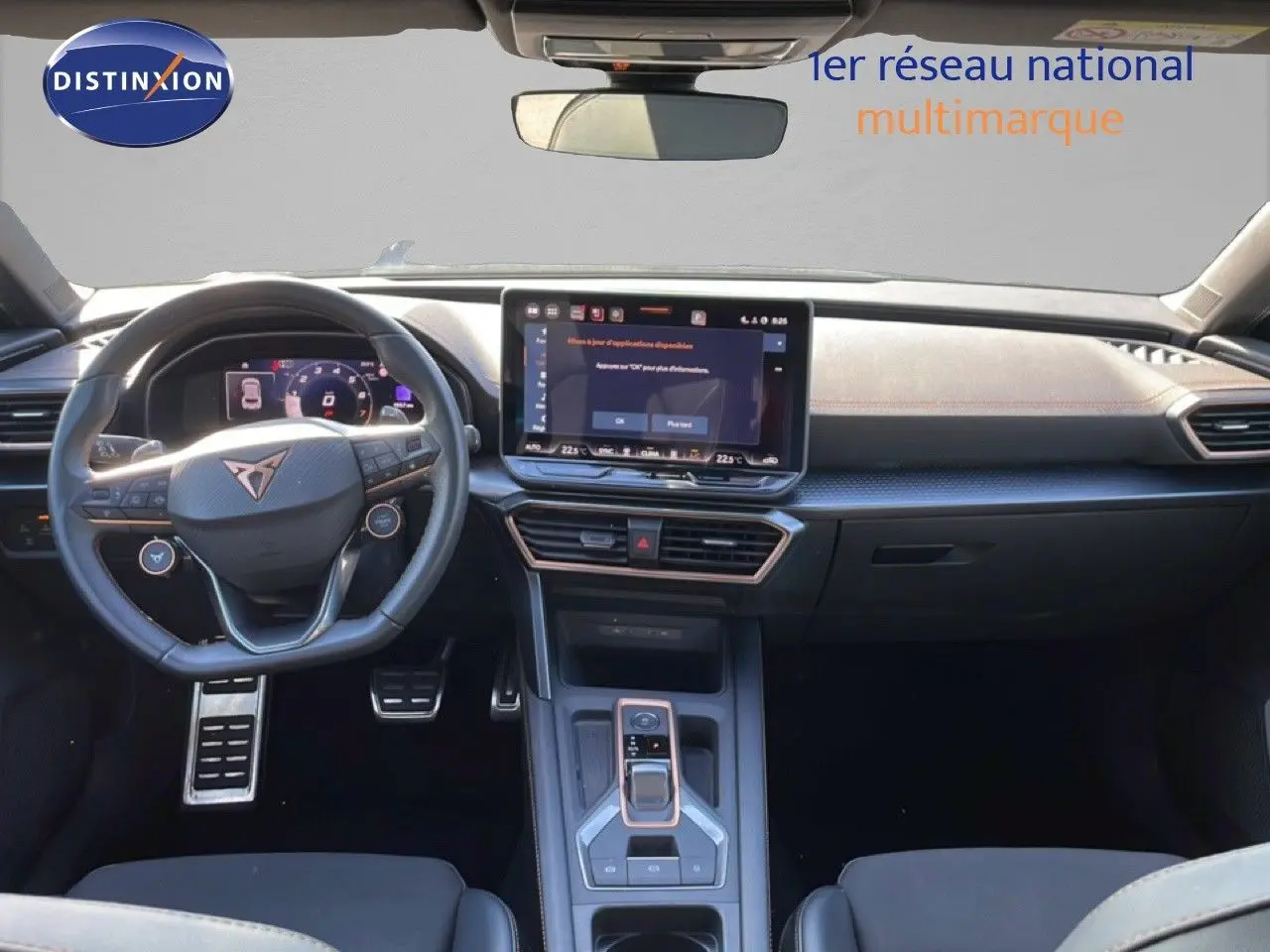 Vue intérieure avant du tableau de bord et volant cuir noir du CUPRA Leon 1.5 eTSI 150CH DSG, avec écran tactile central.