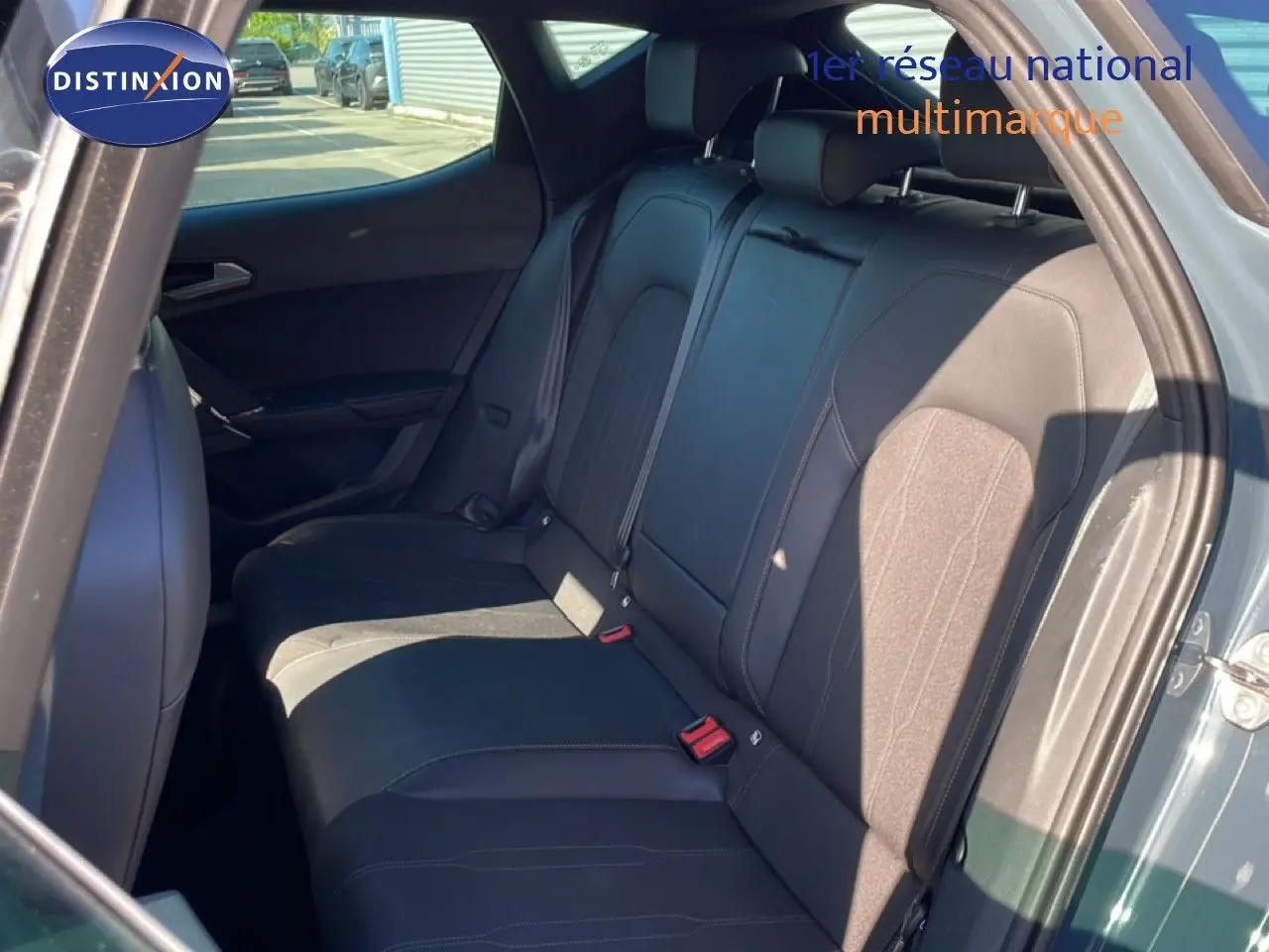 Vue intérieure des sièges arrière en tissu noir de la CUPRA Leon 1.5 eTSI 2025, porte arrière droite ouverte.