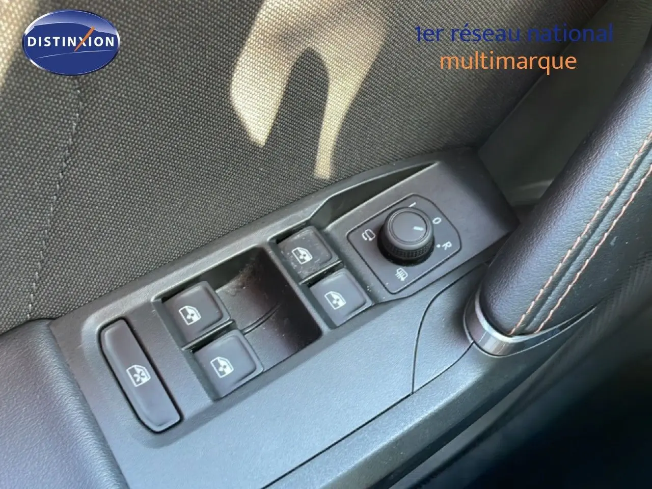Gros plan sur les commandes de lève-vitres et rétroviseurs côté conducteur d'une CUPRA Leon Bleu Fjord 2025.