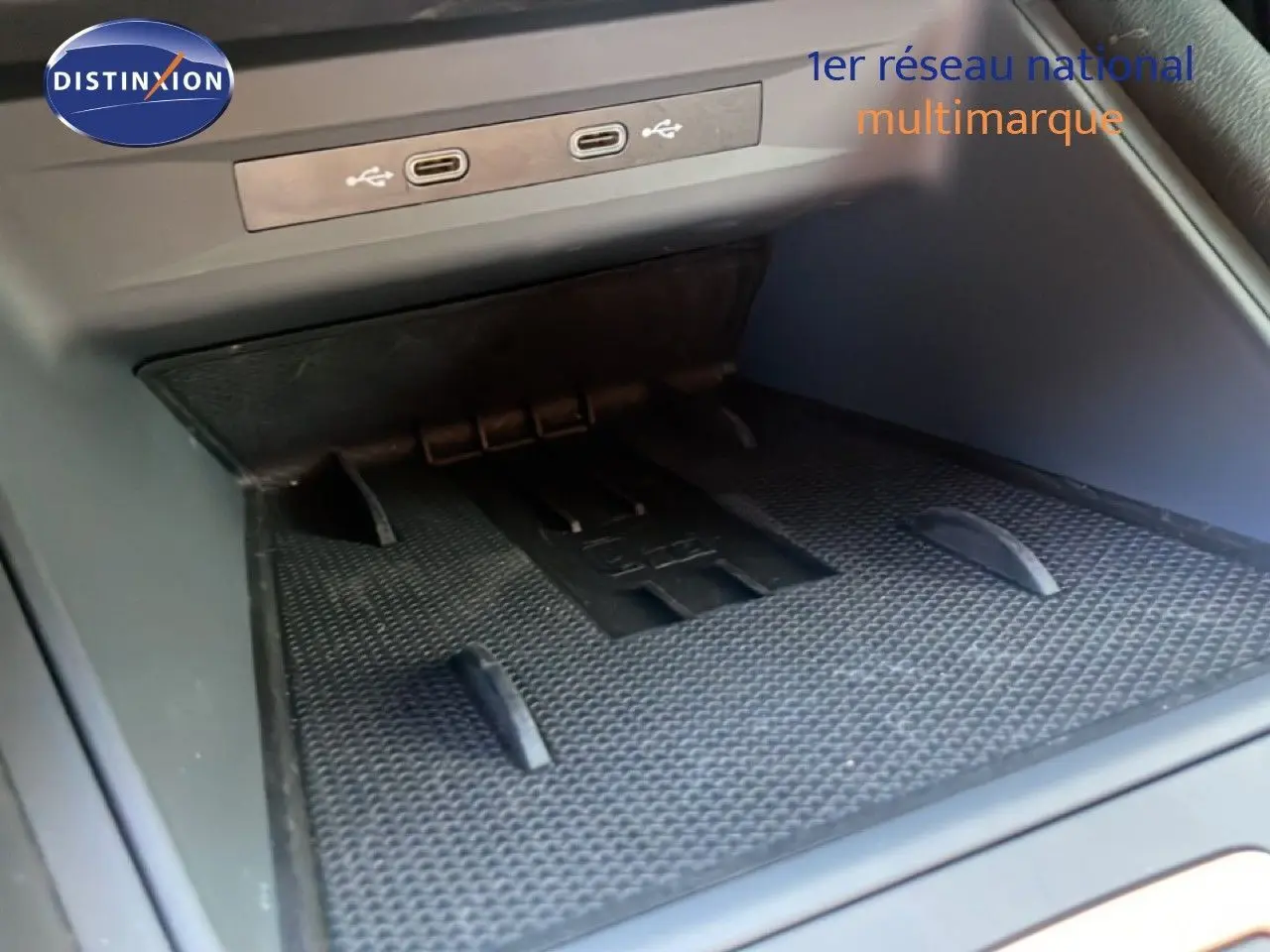 Gros plan sur la console centrale intérieure du CUPRA Leon 1.5 eTSI 150CH DSG avec ports USB et espace de rangement.