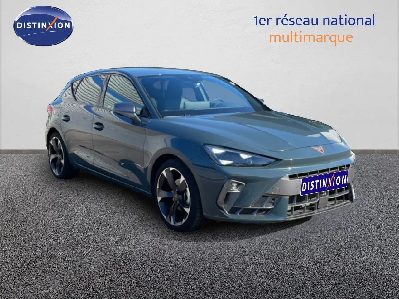 Vue 3/4 avant d'une CUPRA Leon 1.5 eTSI 150CH DSG bleu Fjord avec jantes alliage et calandre distinctive.
