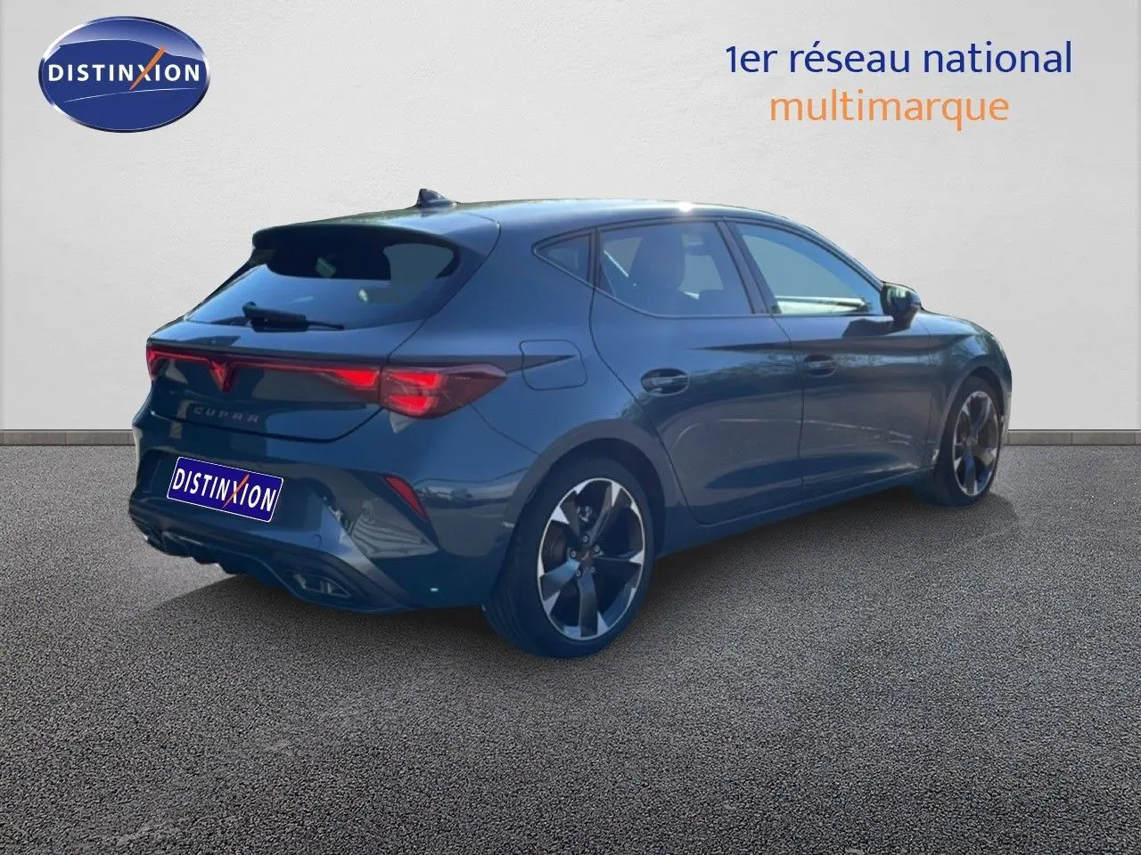 Vue 3/4 arrière droite d'une CUPRA Leon 1.5 eTSI 150CH DSG en bleu fjord avec jantes bi-ton et feux arrière LED.