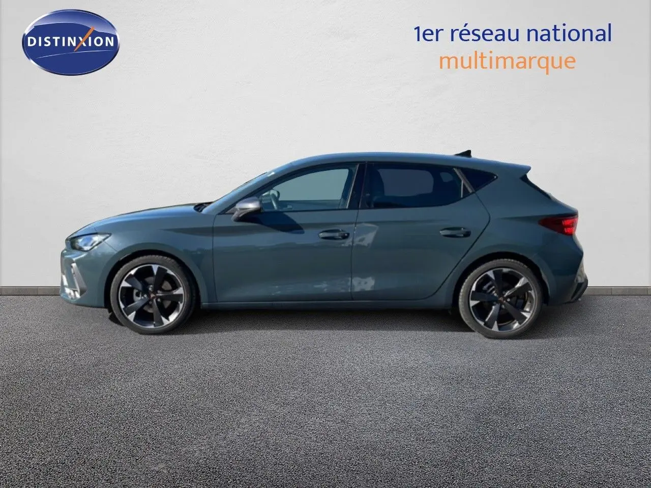 Profil latéral droit d'une CUPRA Leon 1.5 eTSI 150CH DSG en bleu Fjord avec jantes alliage bicolores.