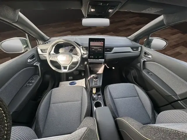 Vue intérieure avant du Renault Captur 2025 gris foncé, avec tableau de bord moderne et grand écran tactile vertical.