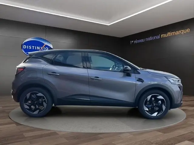 Profil latéral droit d'un Renault Captur 2025 gris foncé avec jantes noires et détails noirs contrastants.