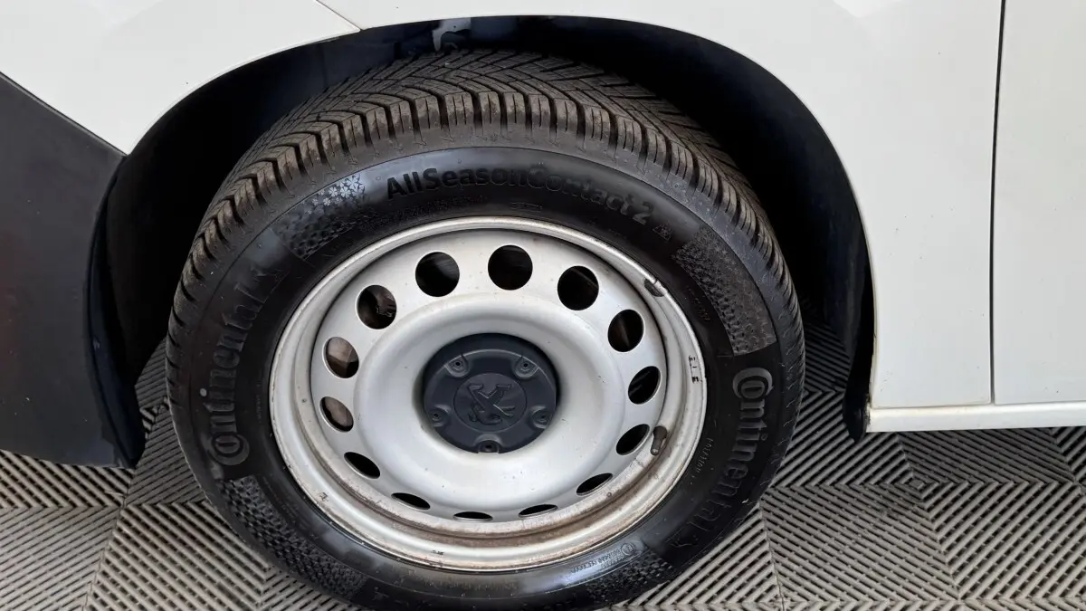 Gros plan sur la roue arrière droite blanche d’un Peugeot Partner 2021 avec jante acier et pneu Continental.