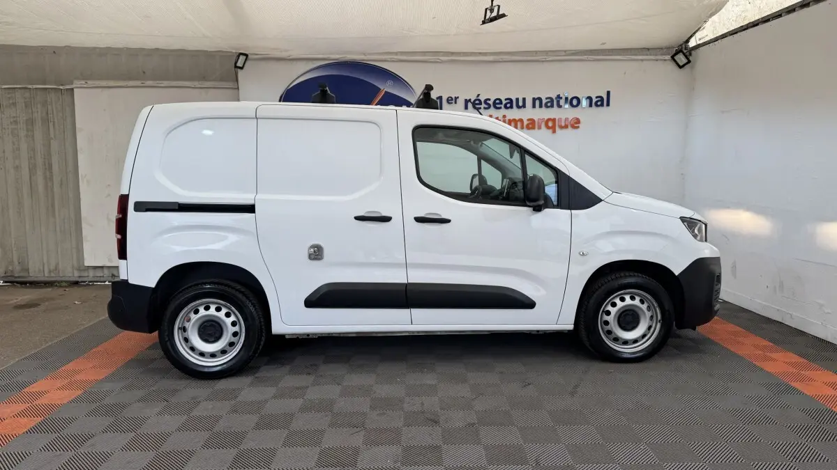 Vue de profil côté gauche d’un utilitaire Peugeot Partner blanc avec porte latérale coulissante et jantes acier.
