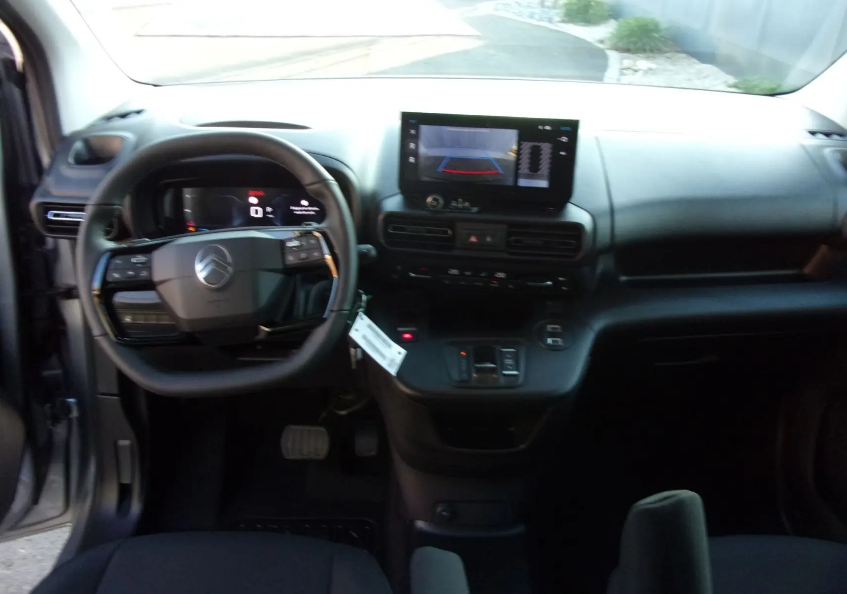 Vue arrière ouverte du Citroën Berlingo gris Artense 2025, montrant l’espace de chargement et la grille de séparation intérieure.