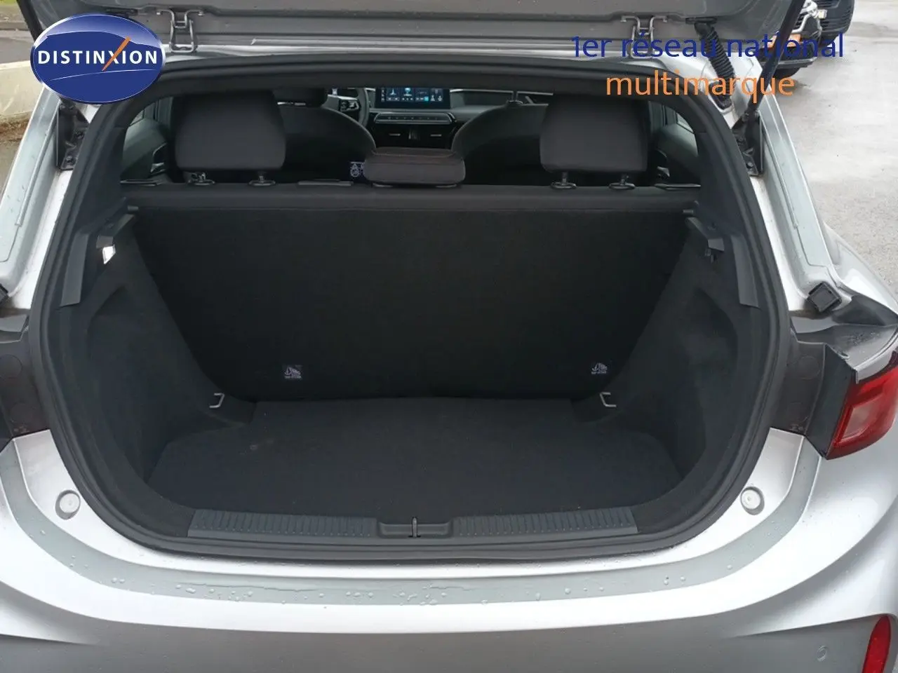 Coffre ouvert d'une MG3 Hybrid+ gris 2024, vue arrière montrant l'espace de chargement et la banquette rabattable.