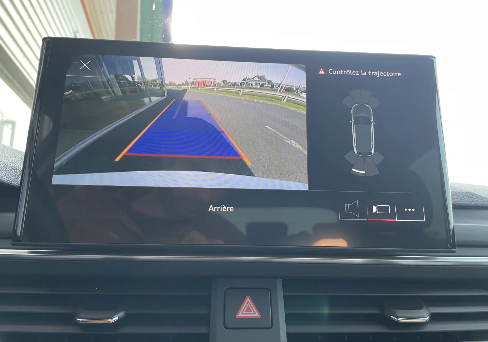 Écran multimédia montrant la caméra de recul avec trajectoire assistée d'une Audi A4 Avant blanche, vue arrière.