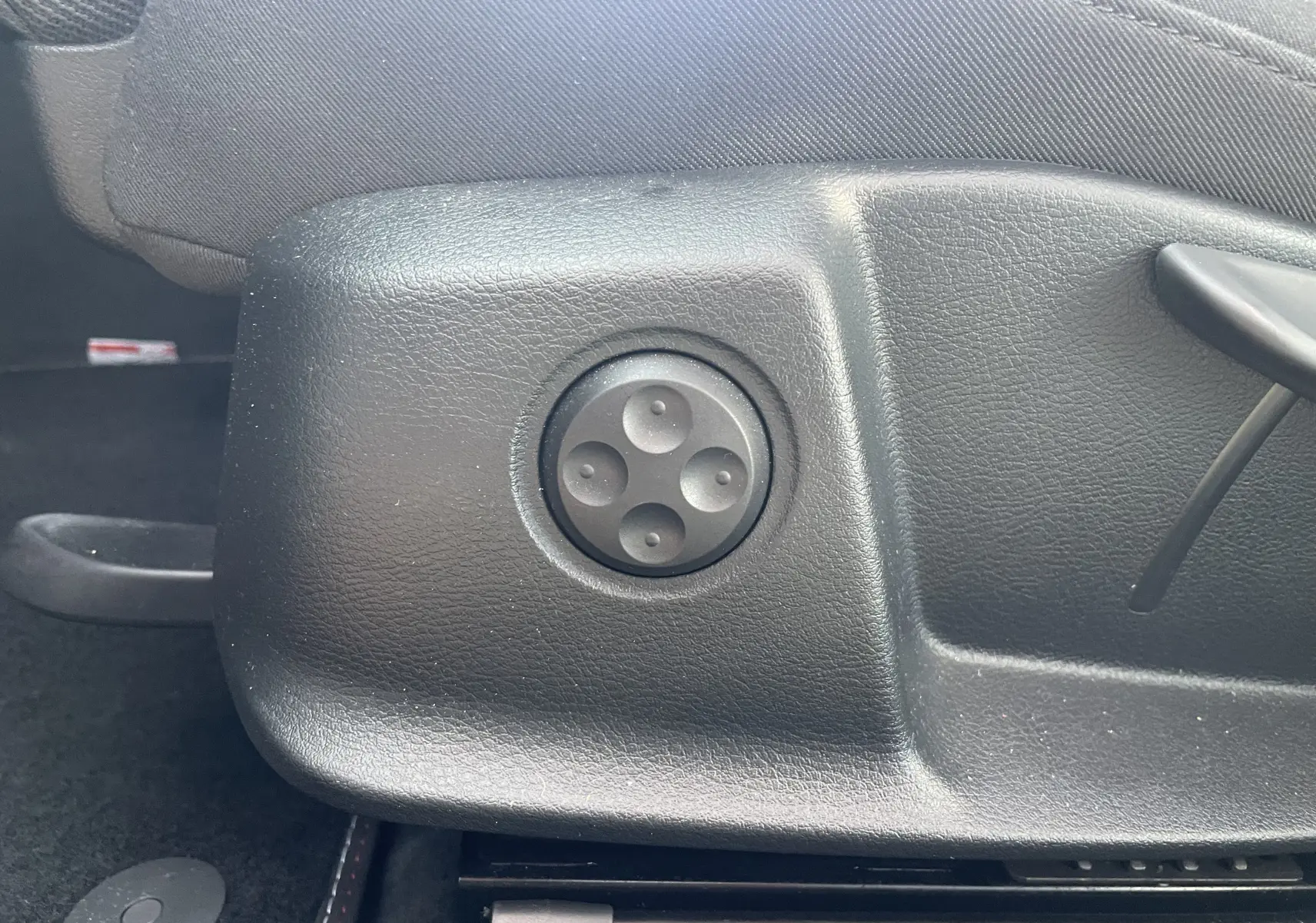 Gros plan sur la commande de réglage électrique du siège côté conducteur d'une Audi A4 Avant blanche de 2022.