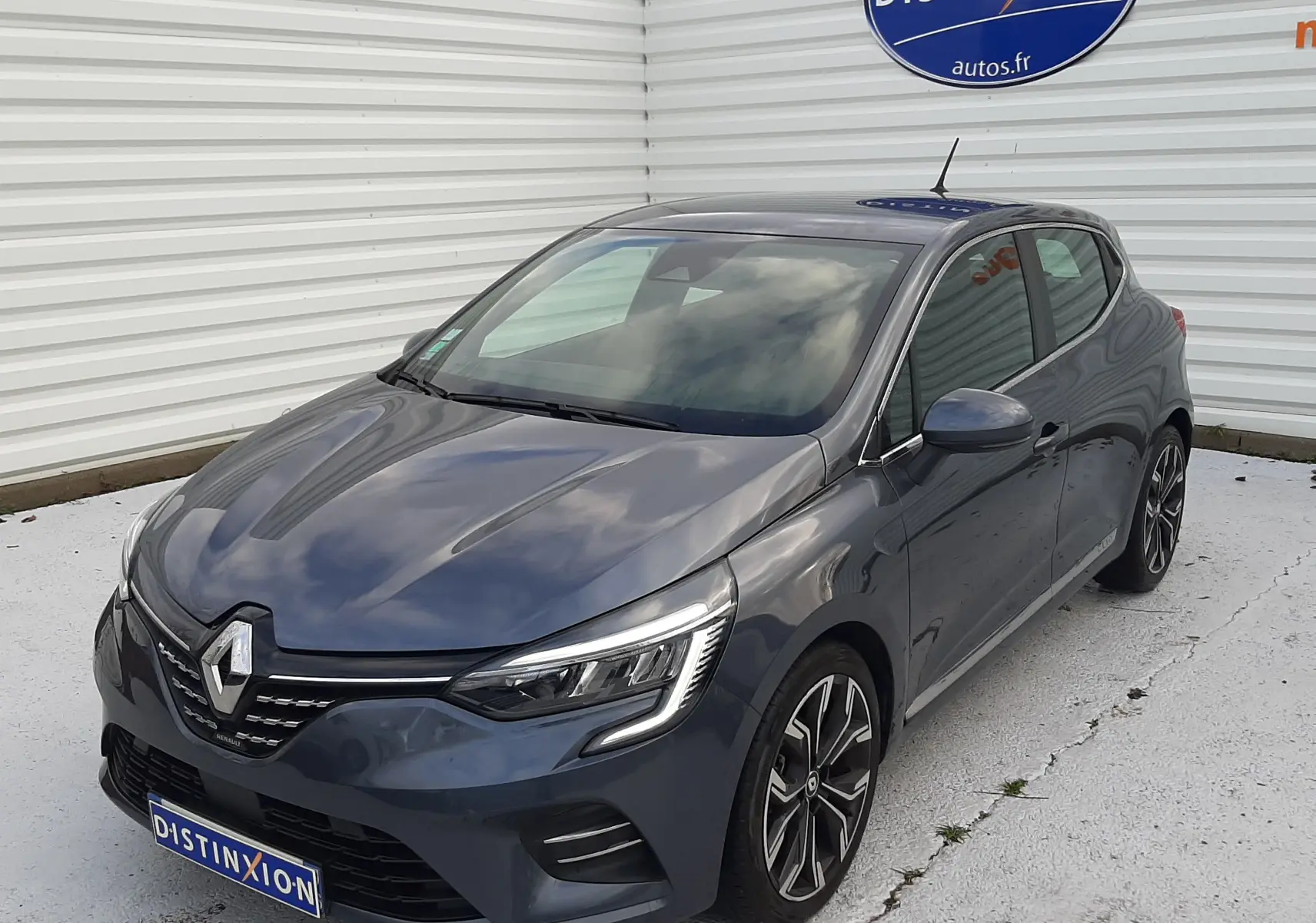 Renault Clio V gris titanium vue 3/4 avant droit, avec phares LED et jantes alliage bicolores.
