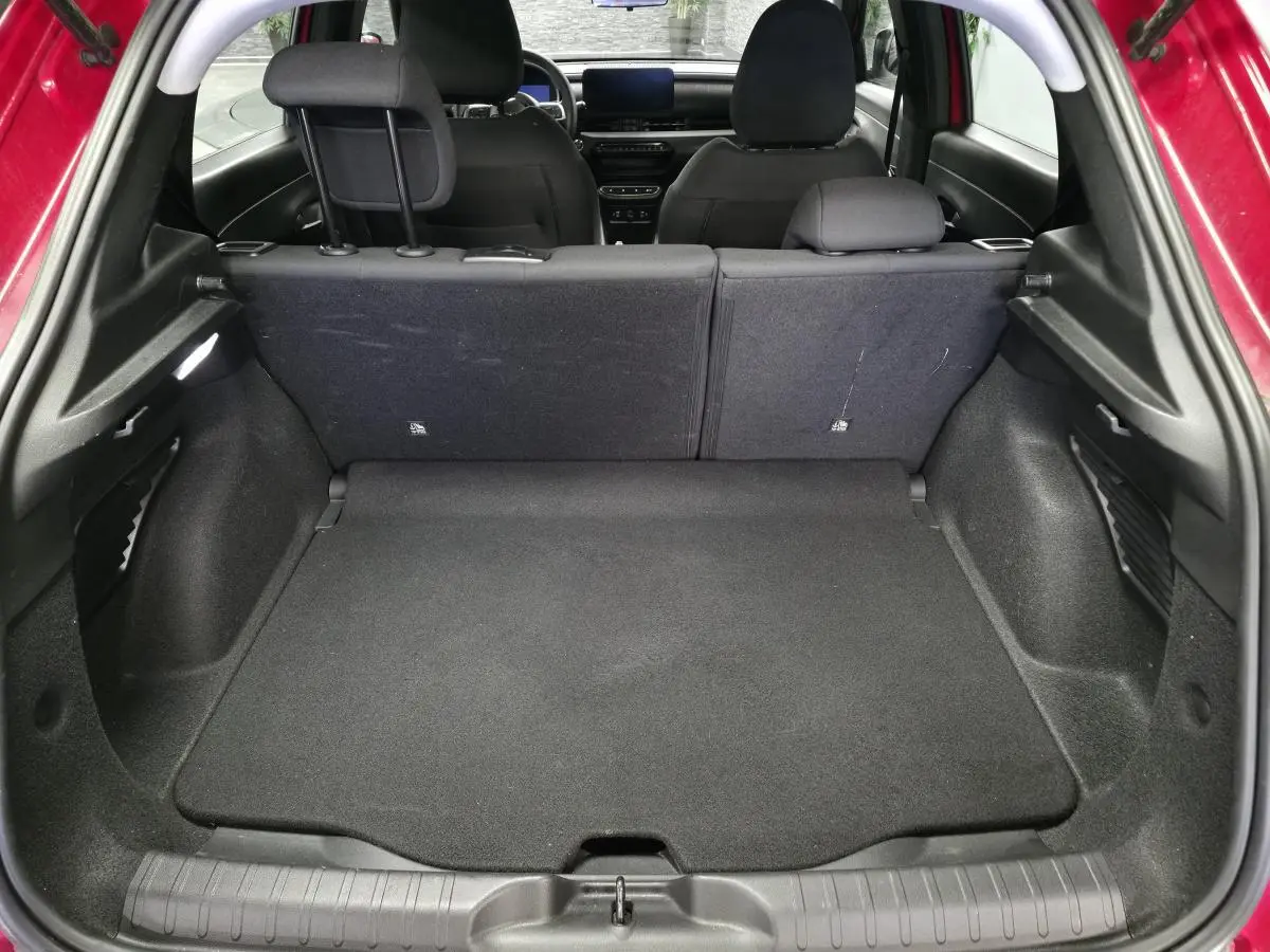 Coffre ouvert d'une FIAT 600 rouge 2024, vue arrière montrant banquette arrière et plancher de coffre modulable noir.