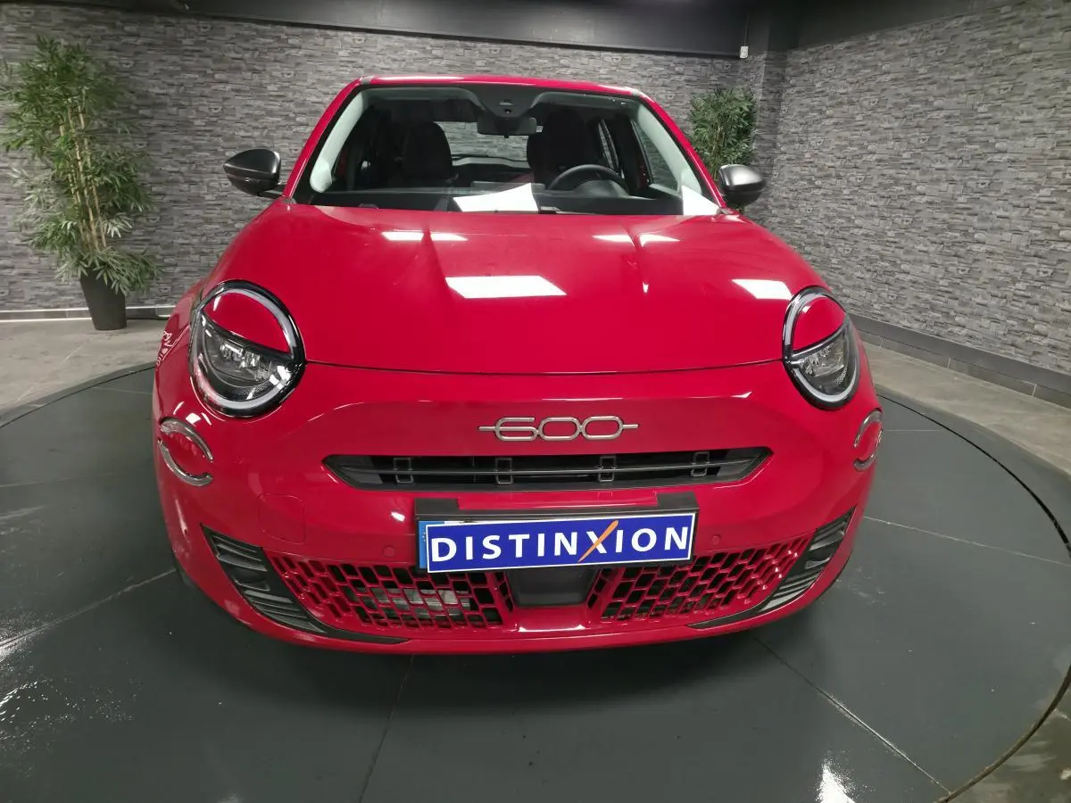 Vue frontale d'une FIAT 600 rouge avec phares ronds et logo 600 au centre du capot