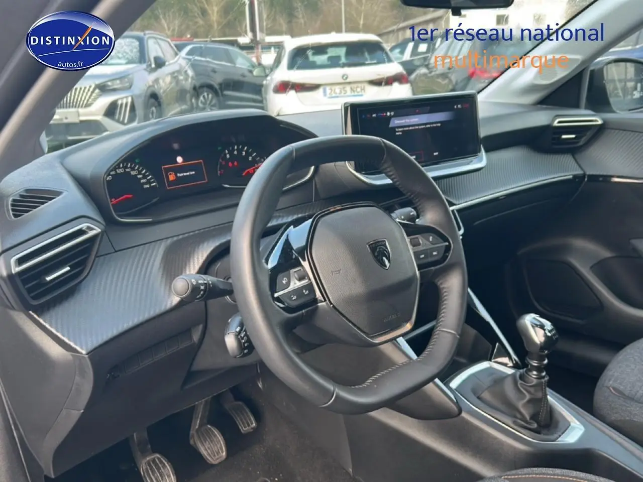 Vue intérieure côté conducteur du Peugeot 208 gris Artense 2025, volant compact et boîte manuelle en évidence.