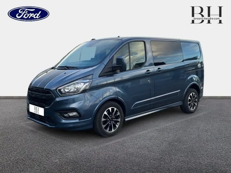 Ford Transit Custom Fourgon bleu azur métallisé vu en 3/4 avant droit avec jantes alu et vitres surteintées.