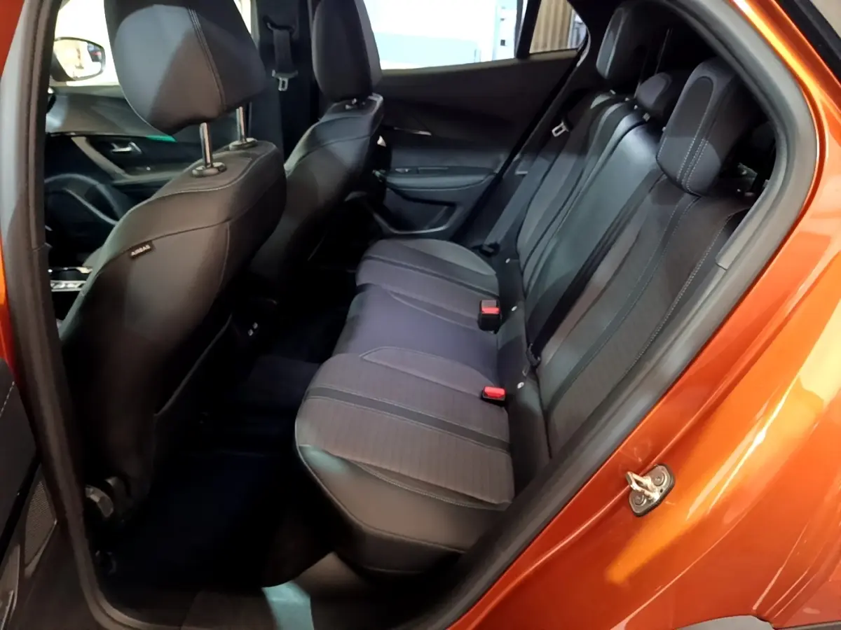 Vue intérieure côté arrière droit montrant la banquette noire et grise du Peugeot 2008 orange 2021.